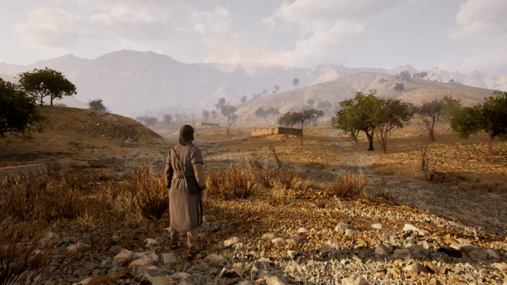 Hanzalah standing in a rocky, semi-arid landscape with scattered trees and distant mountains in the Mystic game.